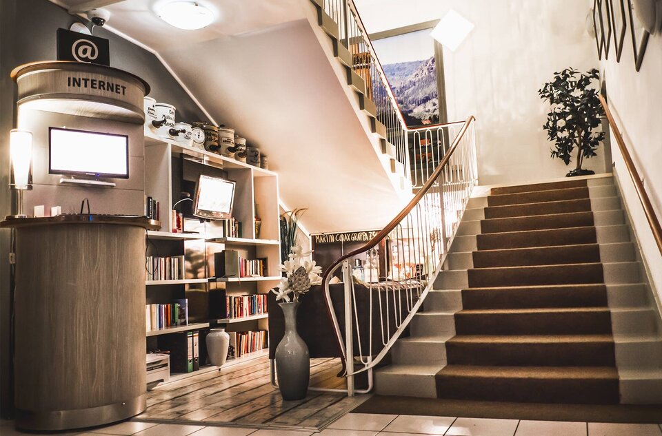 Eine Treppe mit einem Fernseher, Sofa und einem Bücherregal